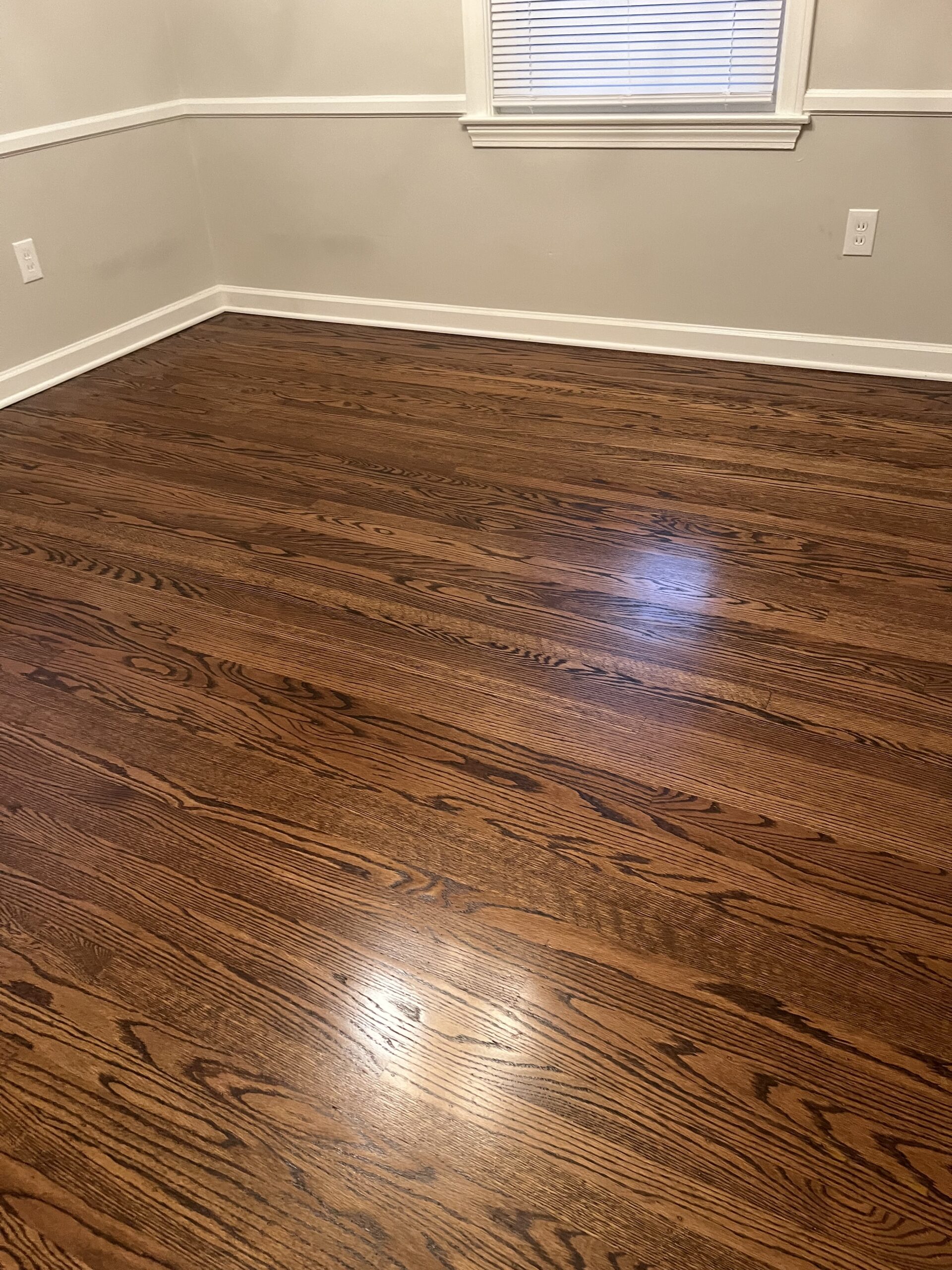 A beautifully restored hardwood floor in a room, showcasing the elegance and smooth finish achieved through professional hardwood floor sanding.